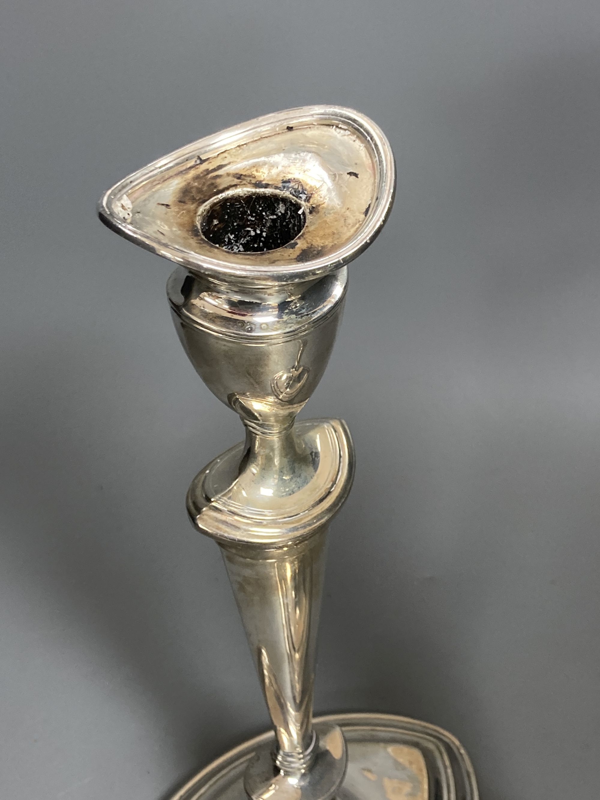 A pair of Edwardian silver oval candlesticks, by Goldsmiths & Silversmiths Co Ltd, London, 1903, loaded, 30.3cm, (sconces a.f. and stuck in situ).